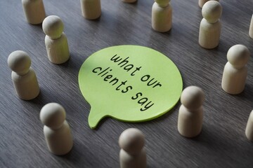 A group of wooden figurines surrounding a speech bubble with text WHAT OUR CLIENTS SAY. Business,...