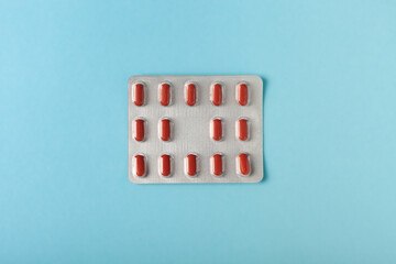 pills and tablets in a blister pack on blue background. Top view. healthcare and medicine concept.