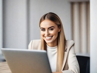 Fototapeta premium a young smiling beautiful woman is working at a laptop in the office