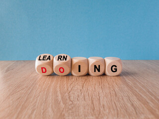 Learning by doing concept. Turned a dice and changes the red word learning to doing, or vice versa....