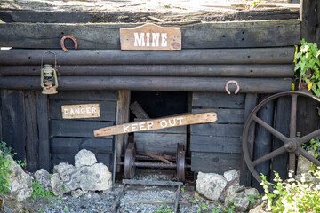 gold Rush with rusty wagon in the old abandoned golden mine in the old west with wooden panel text...