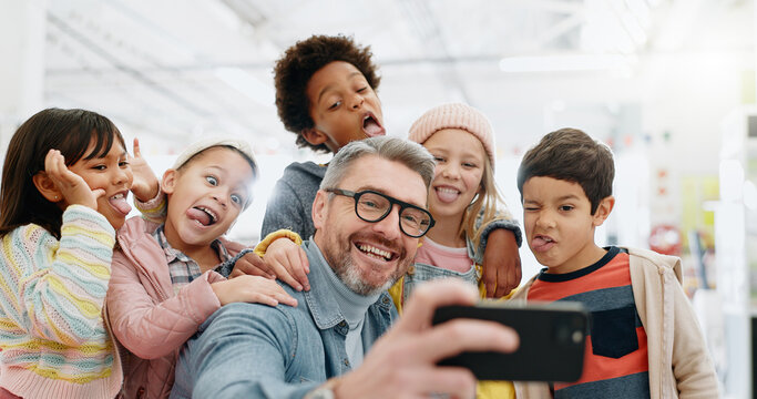 Selfie, children and teacher with funny face, smile and picture with educator, excited and happy. Kids, internet and cellphone for technology, online and memories for school, classroom or diversity