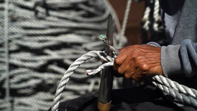 Craftsman making thick rope for a commercial fishing boat or for the harbour