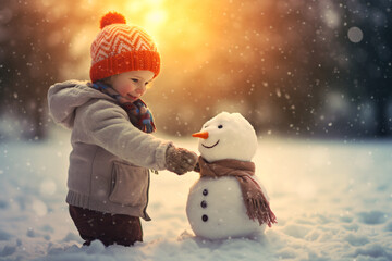 A cute toddler girl making snowman at the park in winter, winter and Christmas background.