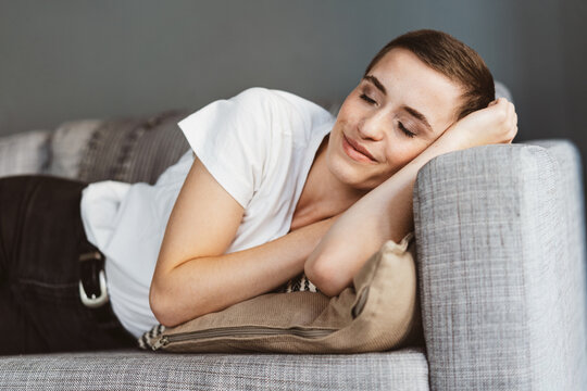 Young Modern Woman with Short Hair Sleeping Peacefully on the Sofa
