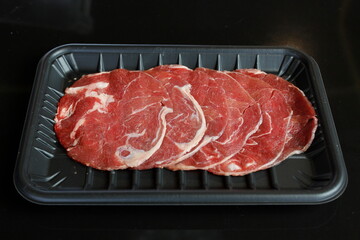 Sliced ​​beef in a black plastic tray
