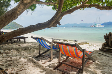 Fototapeta na wymiar Two empty beach chairs on beach. Beach chair or beach loungers on sand at the beach. Summer holiday travel vocation concept. Minimalist beach scene.