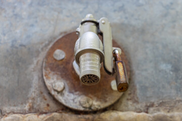 A water tap on the cistern locked with a padlock, close up