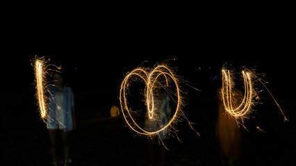 A word i LOVE u was written by firework and slow shutter speed camera.Written with sparkler firework.