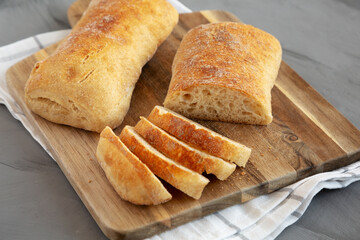 Homemade Ciabatta Bread on a wooden board, side view.