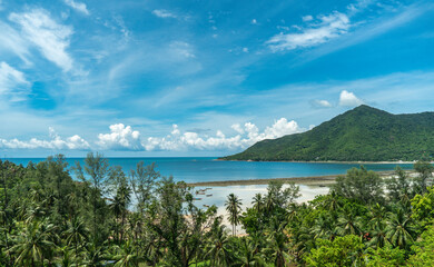 Fototapeta na wymiar Panoramic view of a tropical beach, calm blue ocean, lush green rainforest, Chalokum beach on Koh Phangan coastline island, Thailand, beautiful summer day.