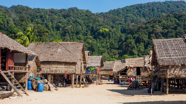 Traditional long-tail boats and houses of Morkan tribe Village or Sea Gypsies and tropical waters of Surin Islands. Fisherman village landscape of Ko Surin Marine National Park.