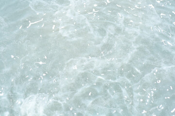 Obraz premium Bluewater waves on the surface ripples blurred. Defocus blurred transparent blue colored clear calm water surface texture with splash and bubbles. Water waves with shining pattern texture background.