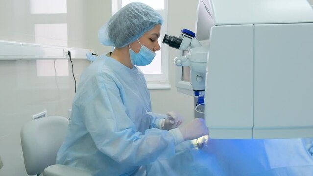 Eye surgery process. The surgeon looks through an ophthalmic microscope. Laser eye correction using SMILE method.