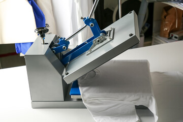 Printing logo. Heat press with t-shirt on white table