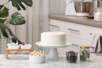 Delicious cake and sweets for decoration on white marble table in kitchen