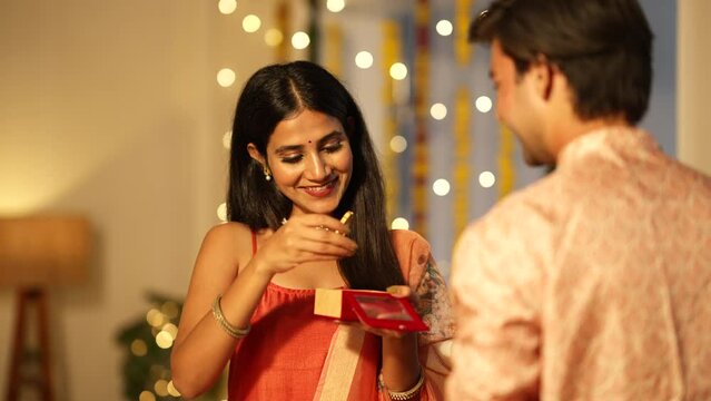 Handsome Indian man gifting gold bangles to his beautiful wife on the Diwali festival.Indian woman getting a precious gift from her loving husband during the festival celebrations.