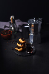 Chocolate eclairs with a cup of coffee and a coffee pot