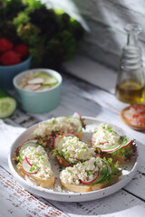 A plate with sandwiches with cottage cheese, radish and cucumber in rustic style