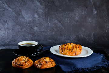Peach Danish pastry puff served in plate with cup of black coffee isolated on napkin side view of...