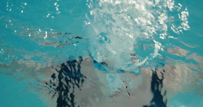 Swimmer woman dives under water swimming pool portrait in close up