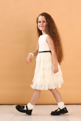 little model girl with long brown hair in designer white dress with belt, military boots full body photo walking.