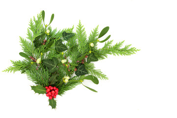 Christmas winter greenery floral bouquet with holly, mistletoe, ivy, pine cones, cedar. Traditional nature flora for  festive holiday season, Yule, Noel, New Year.