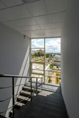 Concrete staircase leading from top to bottom, in an office building.