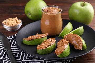 Slices of fresh green apple with peanut butter on wooden table - Powered by Adobe