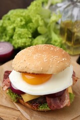 Delicious burger with fried egg on table, closeup. Space for text