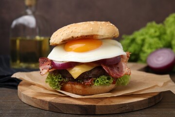 Delicious burger with fried egg on wooden table