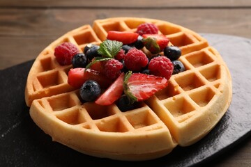 Tasty Belgian waffle with fresh berries on table, closeup