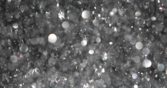 White silver glitter bokeh with stars abstract background. Gray sparkles fly on a black background