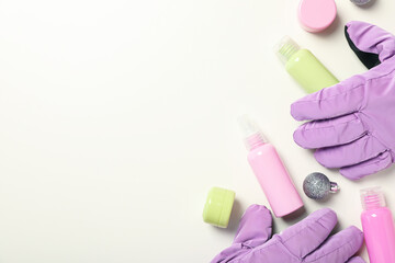 Cosmetic bottles and jars, ski gloves on white background, space for text