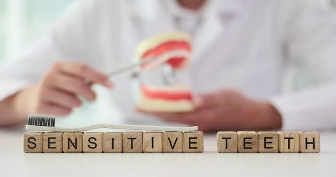 Word Sensitive Teeth with toothbrush on top and dentist. Dentist and treatment of tooth sensitivity