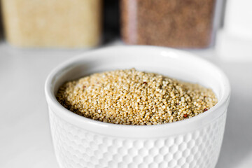 White quinoa on the white plate on the background of a modern kitchen. Healthy food and nutrition concept. Safe, ecological, and healthy products