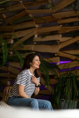 Profile view of a happy woman in room sit down. 