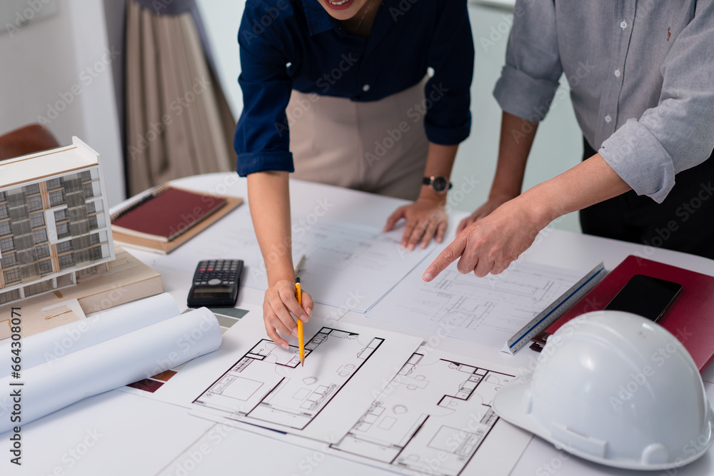 Aufkleber two architects pointing on blueprint to discuss and planning about construction building project