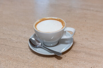 cup of cappuccino with foam and a spoon