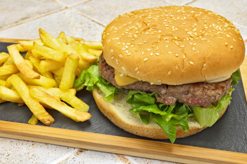 burger au boeuf et frites, en gros plan, sur une planche à découper