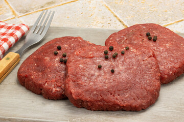 steaks hachés de boeuf crus, en gros plan, isolé sur une table