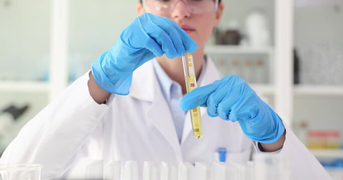 Scientist in gloves doing research on ph strip in microbiology laboratory. Testing acidity of liquids
