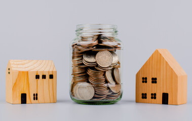 Coins and houses Saving coins in a glass jar Coin bank, finance and financial investment Cash...