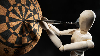 Wooden dummy sticks a dart into a target