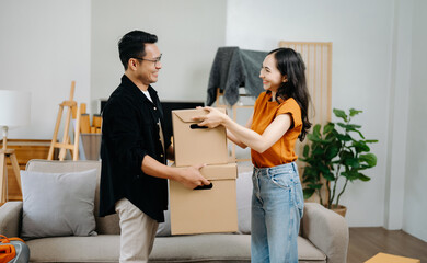 Happy asian young attractive couple man and woman with big boxes moving into a new house, new apartment for couple the new home, Moving house. on sofa..