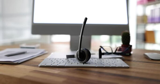 Headset with microphone on computer keyboard. Call center operator workplace and telemedicine