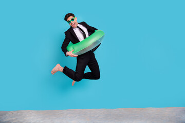 Full length photo of cheerful positive guy dressed black tuxedo jumping enjoying summer vacation...