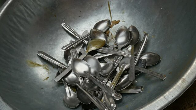 Spoons are thrown in a basket in the communal kitchen of the Golden Temple in Amritsar, India