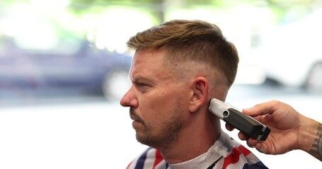 Closeup of man hairstyle and haircut using barber shaving machine and haircut for man. Hairdressing services with razor in modern barbershop