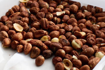 Fresh, young, unroasted hazelnuts or hazelnut kernels. Against the background of a delicate white curtain. Daylight. Natural color.
